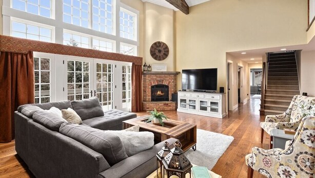 Un salón amplio con chimenea, un televisor grande y asientos cómodos.