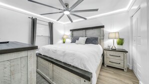 A bedroom with a bed, bedside tables, a ceiling fan, and a window with blinds. - 1605 Oceanfront Pelican Beach Resort Amazing Location Multiple Pools & Hot Tubs (Destin)
