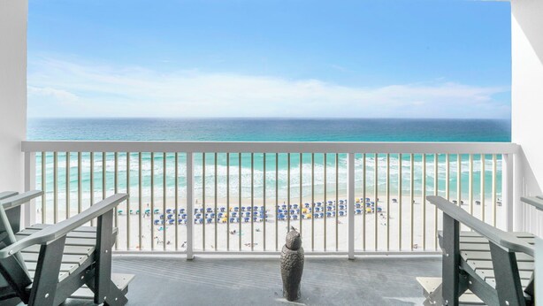 A balcony with a view of a beach, a statue, and a railing. - 1605 Oceanfront Pelican Beach Resort Amazing Location Multiple Pools & Hot Tubs (Destin)