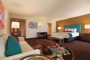 A hotel room with a bed, a sofa, a desk, and a coffee table. - 1-Bedroom Suite at a  Hotel (Las Vegas)