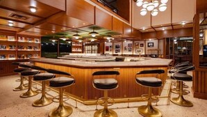 Eine Bar mit einer zentralen Theke und mehreren Barhocker.