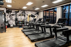 Een sportschool met loopbanden, fitnessballen en krachtapparaten.