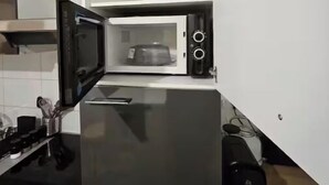 A compact kitchen with a microwave, a stove, and a sink.