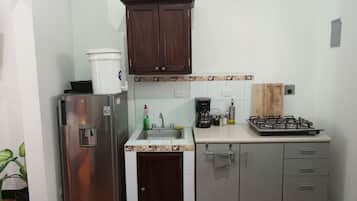 Placa de cocina, cafetera o tetera, utensilios de cocina y especias