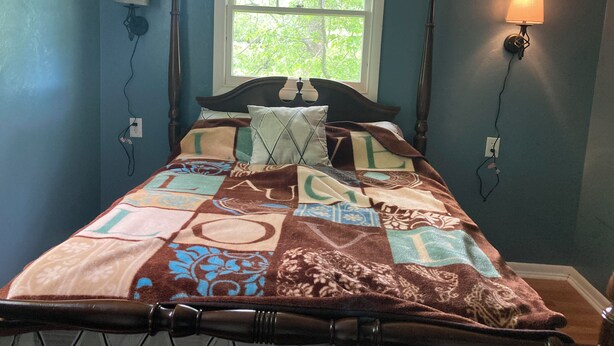 A bedroom with a bed, a window, and two wall-mounted lamps. - Hillside Hideaway (Weber City)