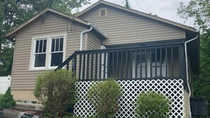 A two-story house with a covered porch and a garage. - Hillside Hideaway (Weber City)