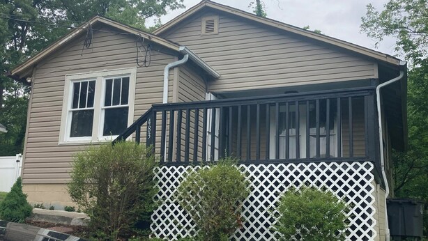 A two-story house with a covered porch and a garage. - Hillside Hideaway (Weber City)