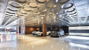 A modern parking garage with a unique ceiling design featuring circular patterns. - Brown Dot Hotel Gumi Okgye Branch (Gumi)