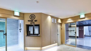 A modern hotel lobby with a reception desk, glass doors, and a clear view of the interior. - Brown Dot Hotel Gumi Okgye Branch (Gumi)