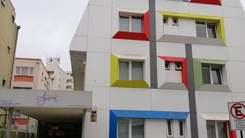 Un hotel de varios pisos con diseño moderno, que destaca un cartel grande con la palabra 'HOTEL' en la parte superior.