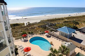 A hotel with a pool, beach view, and outdoor seating area. - 2-BR Beachfront Condo with Balcony Views! (North Myrtle Beach)