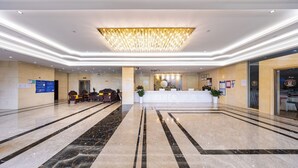 A spacious lobby with a marble floor, a reception desk, and a chandelier. - Xinrun Hua Hotel Hongqiao Park Branch (Shenzhen)