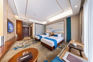 A hotel room with two beds, a TV, a desk, and a small table with a vase. - Xinrun Hua Hotel Hongqiao Park Branch (Shenzhen)