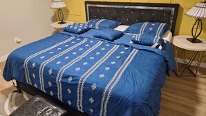 Une chambre à coucher avec un grand lit, deux tables de chevet et une tête de lit.