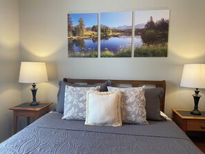 A bed with a grey quilt, two nightstands with lamps, and three landscape paintings on the wall. - Cozy Family Getaway • Pet Friendly • Sleeps 8 • Near RRG • Campton, KY  (Campton)