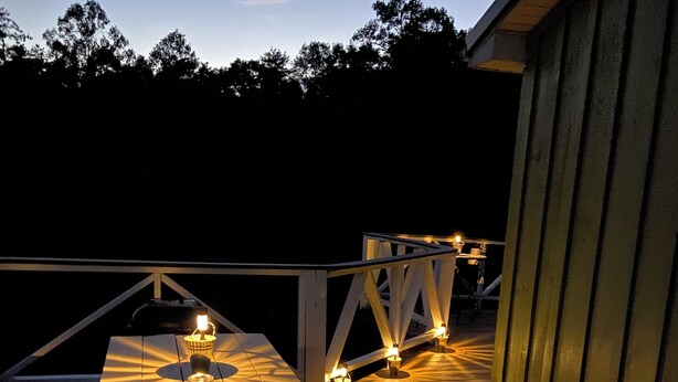 An outdoor wooden deck with a picnic table and string lights. - Cozy Family Getaway • Pet Friendly • Sleeps 8 • Near RRG • Campton, KY  (Campton)