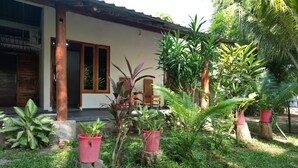 Una casa con porche, plantas en macetas y una silla de madera.