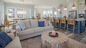 Un salon spacieux comprenant un canapé, une table basse et un coin repas avec des chaises.