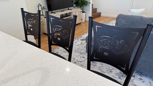 A dining area with a white speckled table and black chairs with embossed designs. - Lux Midtown; Mins to Uptown, Biltmore, Melrose District, Papago Park, & Sports (Phoenix)