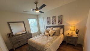 A bedroom with a bed, a dresser, a nightstand, a ceiling fan, a window with blinds, and wall art. - Lux Midtown; Mins to Uptown, Biltmore, Melrose District, Papago Park, & Sports (Phoenix)