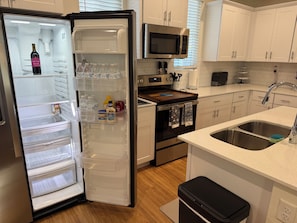 A modern kitchen with a built-in refrigerator, microwave, and oven.