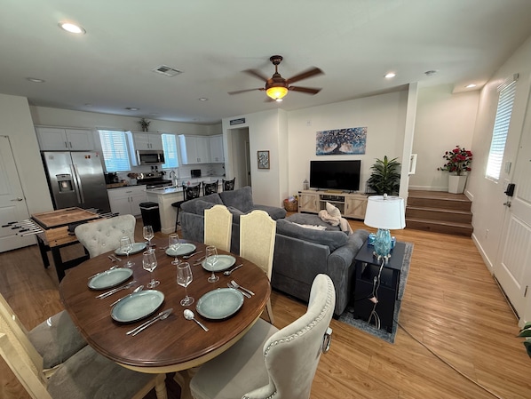 A modern living space with a dining area, kitchen, and seating area.