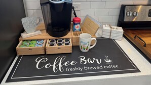 A coffee bar setup with a Keurig machine, coffee pods, a mug, and a sign reading "Coffee Bar freshly brewed coffee". - Lux Midtown; Mins to Uptown, Biltmore, Melrose District, Papago Park, & Sports (Phoenix)