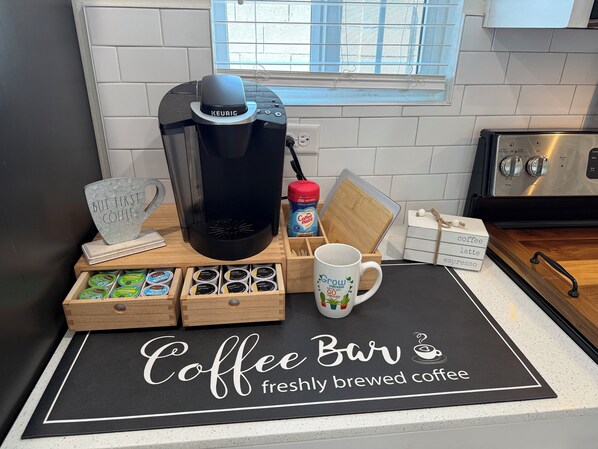 A coffee bar setup with a Keurig machine, coffee pods, a mug, and a sign reading "Coffee Bar freshly brewed coffee". - Lux Midtown; Mins to Uptown, Biltmore, Melrose District, Papago Park, & Sports (Phoenix)