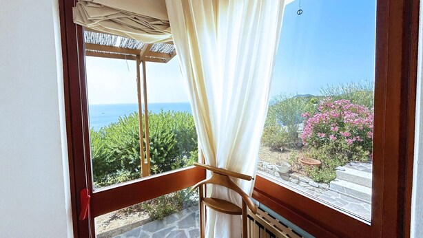 Un balcon avec vue sur la mer et le jardin.