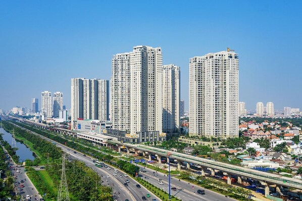 A high-rise building with multiple floors, surrounded by a busy road and a river. - MASTERI THAO DIEN PREMIER APARTMENTS (Ho Chi Minh City)
