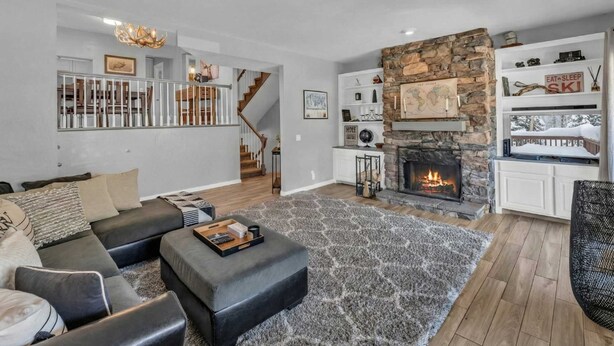 Un salon moderne avec une cheminée, un escalier et un coin repas.