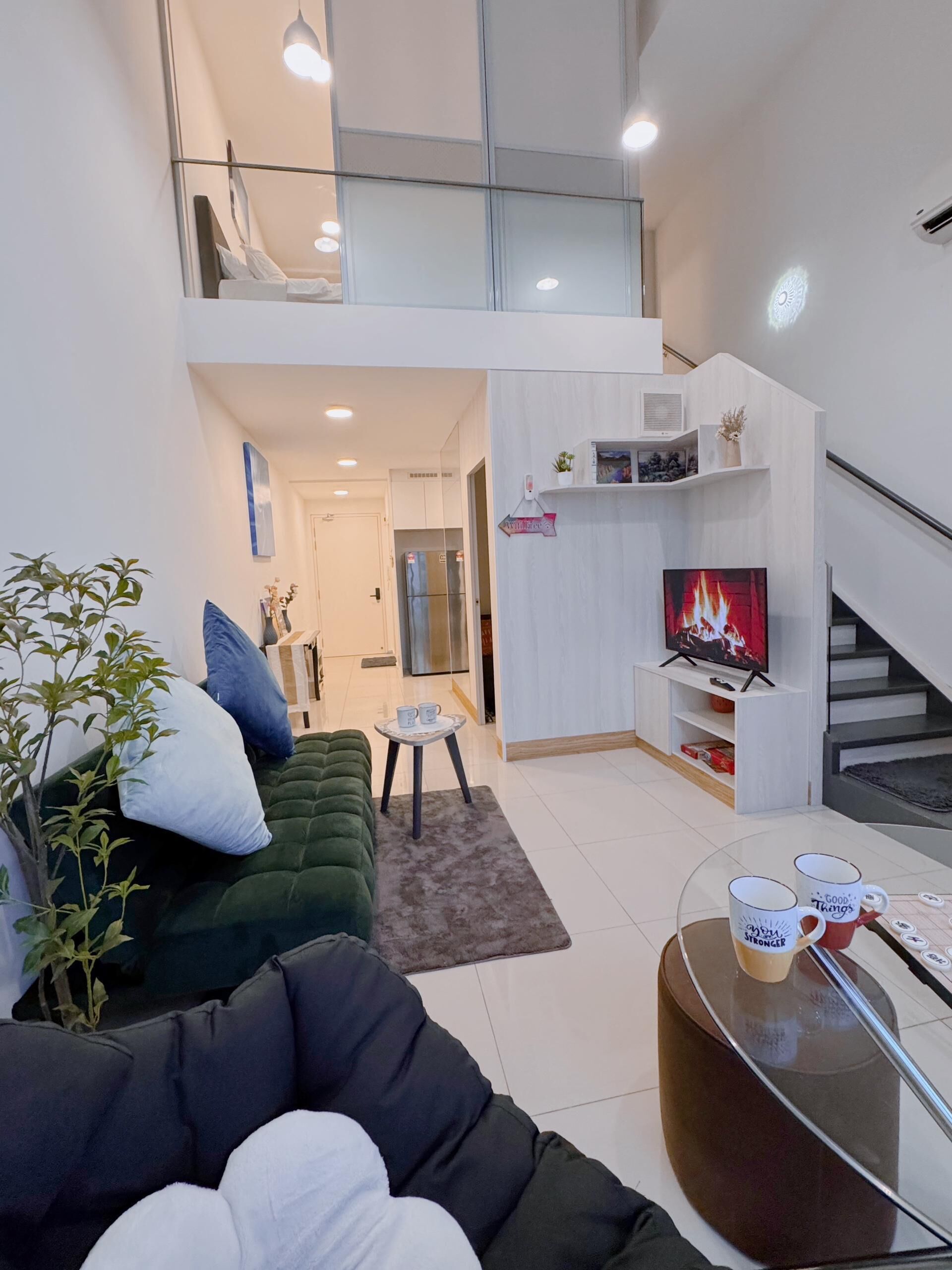 Ein modernes Wohnzimmer mit einem grünen Sofa, einem Couchtisch und einem Kamin.