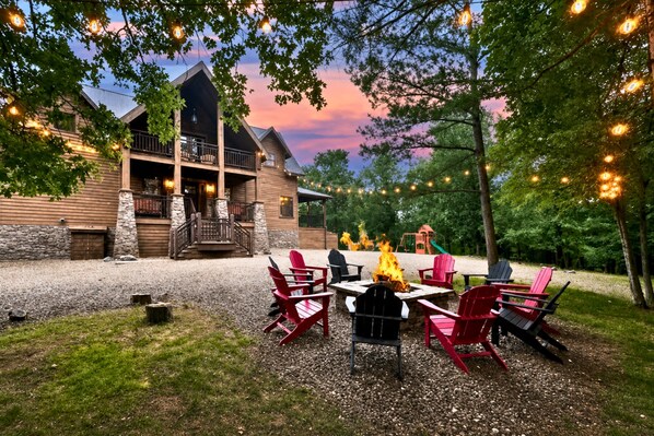 A lodge with a stone exterior, a fire pit, and outdoor seating.