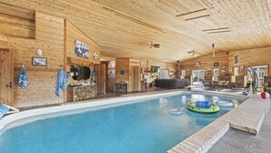 Un intérieur en bois avec une piscine, un sauna et un espace bar.