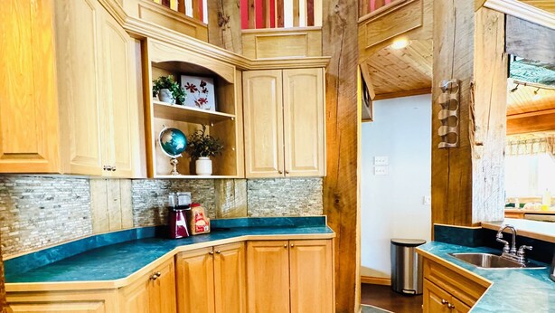 Une cuisine spacieuse avec des meubles en bois, un plan de travail en granit et un îlot central.