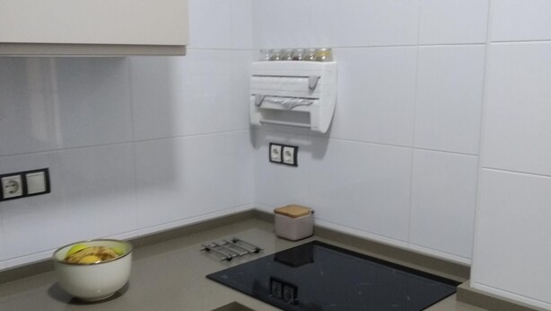 Eine moderne Küche mit schwarzer Arbeitsplatte, einer weißen Spüle und einer kleinen Mülltonne.
