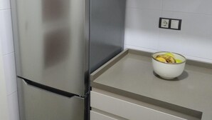 Ein Edelstahl-Kühlschrank in einer Küche mit weißen Schränken und einer Arbeitsplatte.