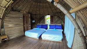 A room with two beds, wooden flooring, and a curved bamboo ceiling. - Aranka Tempasan (Pringgasela)