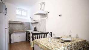Una cocina compacta con comedor, estufa integrada y ventana.