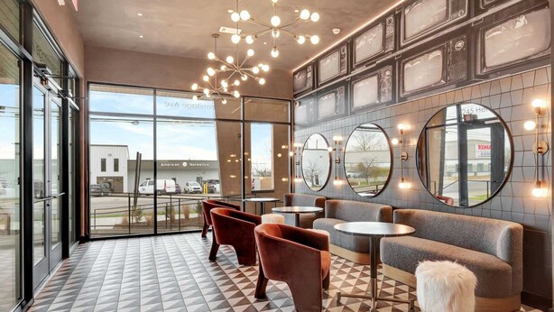 A modern interior with a checkered floor, seating area, and large windows offering a view of the outside. - Nashville Designer PH City Views + Rooftop Access (Nashville)