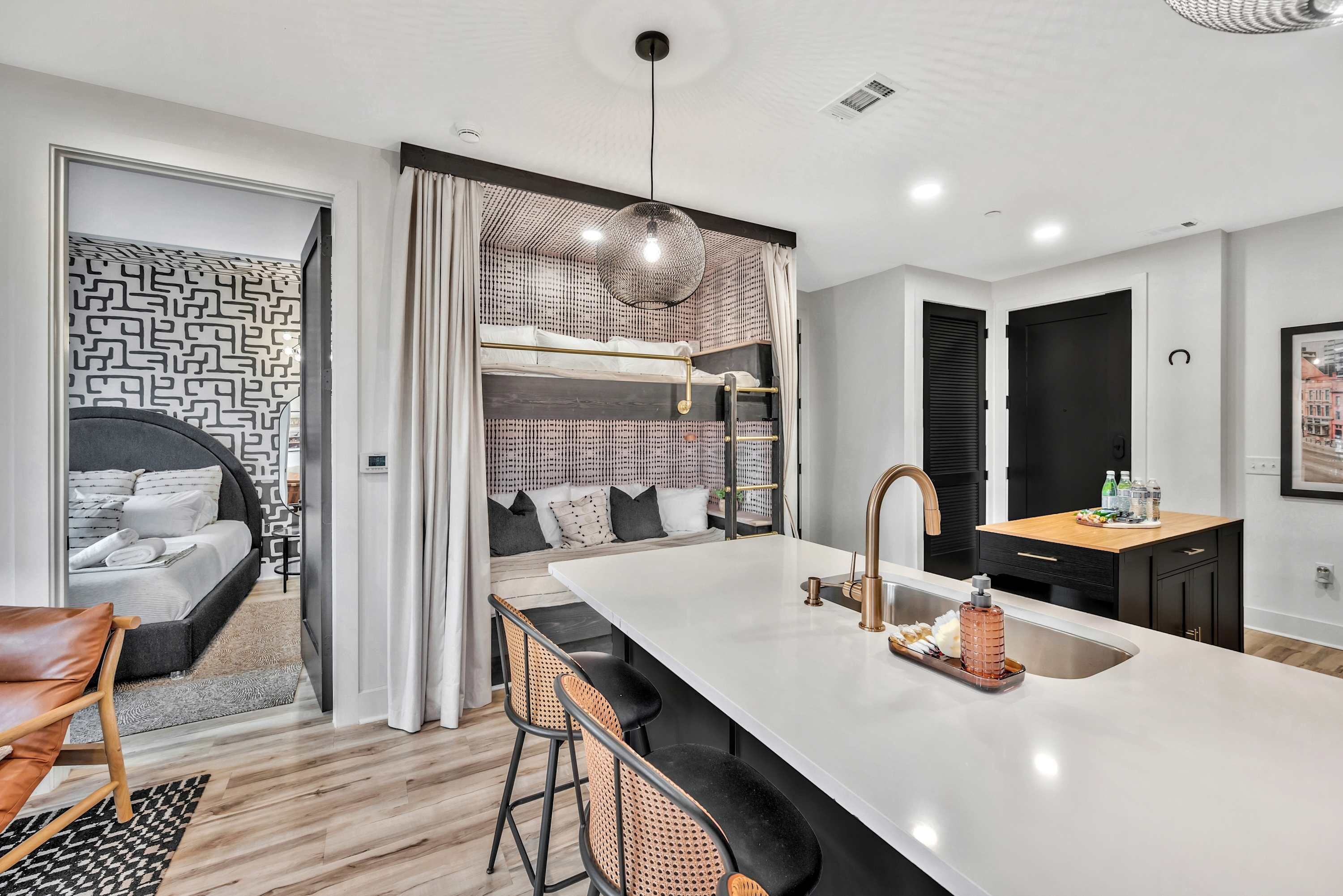 A modern kitchen with a central island, a built-in bench, and a hanging light fixture.