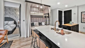 A modern kitchen with a central island, a built-in bench, and a hanging light fixture. - Nashville Designer PH City Views + Rooftop Access (Nashville)