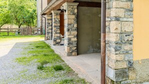 A stone building with a covered porch and a gravel path.