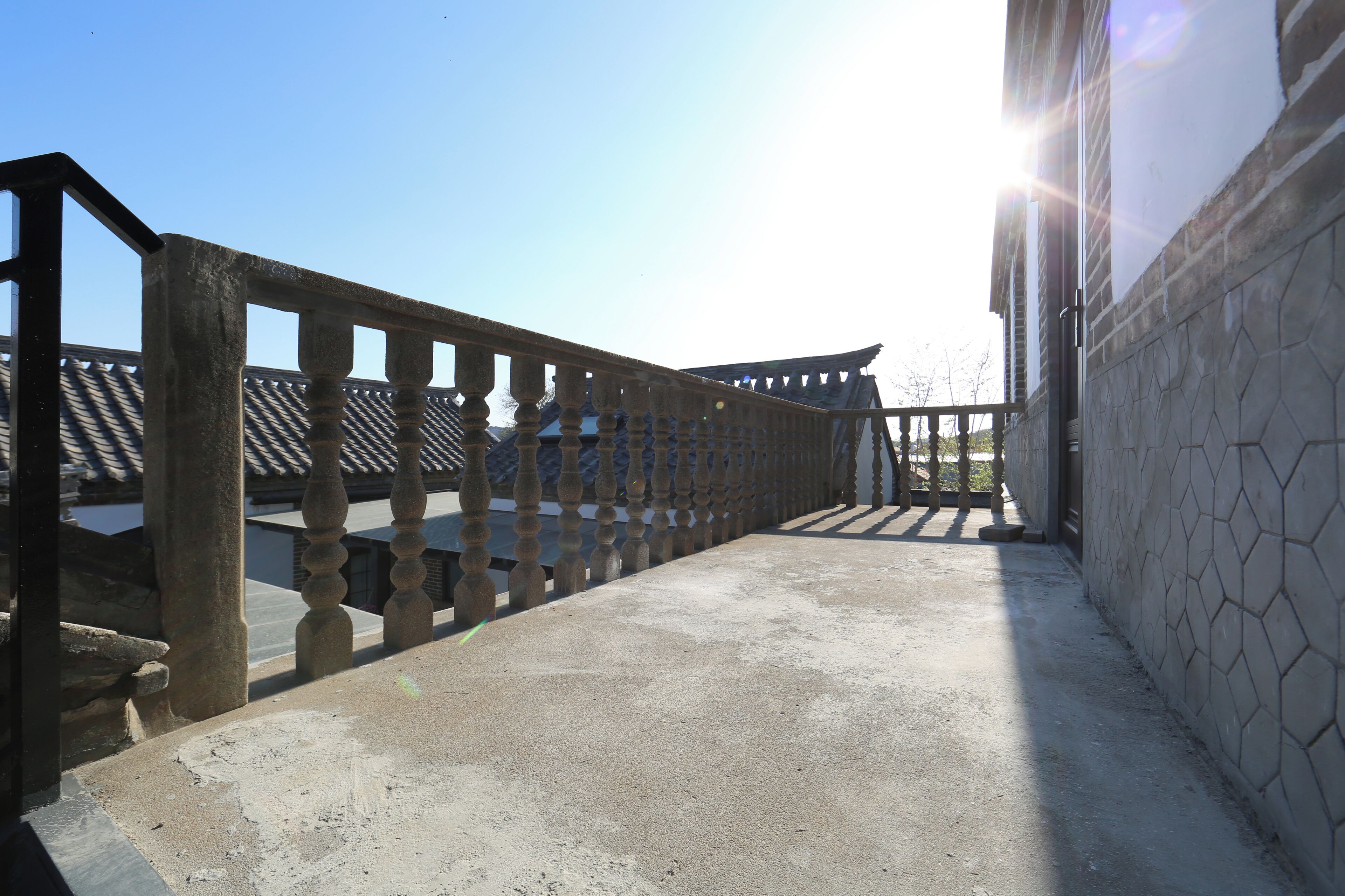 A corridor with a stone wall and a wooden railing.