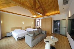 A modern hotel room with a wooden ceiling, a sofa bed, a small table, and a wardrobe. - JOYSEA HUT (Yantai)