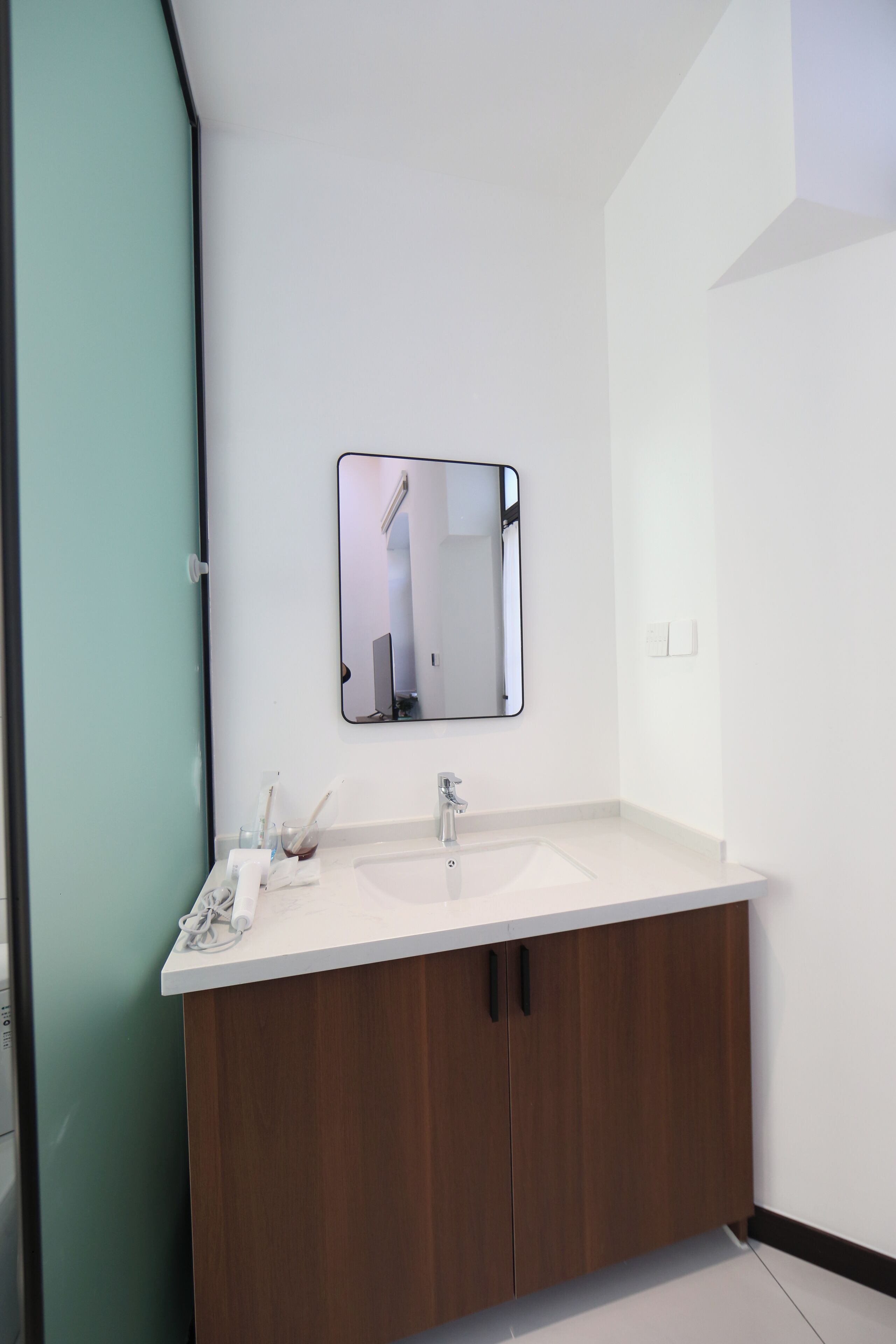 A bathroom with a white sink, a mirror, and wooden cabinets.