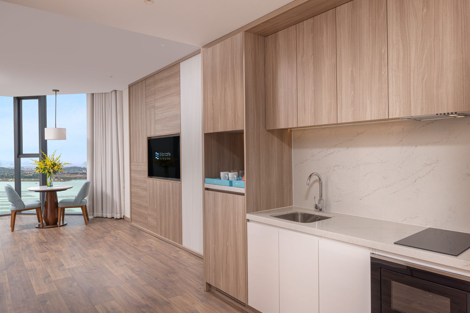 Eine moderne Küche mit Marmorarbeitsplatte, integriertem Spülbecken und Holzschränken.