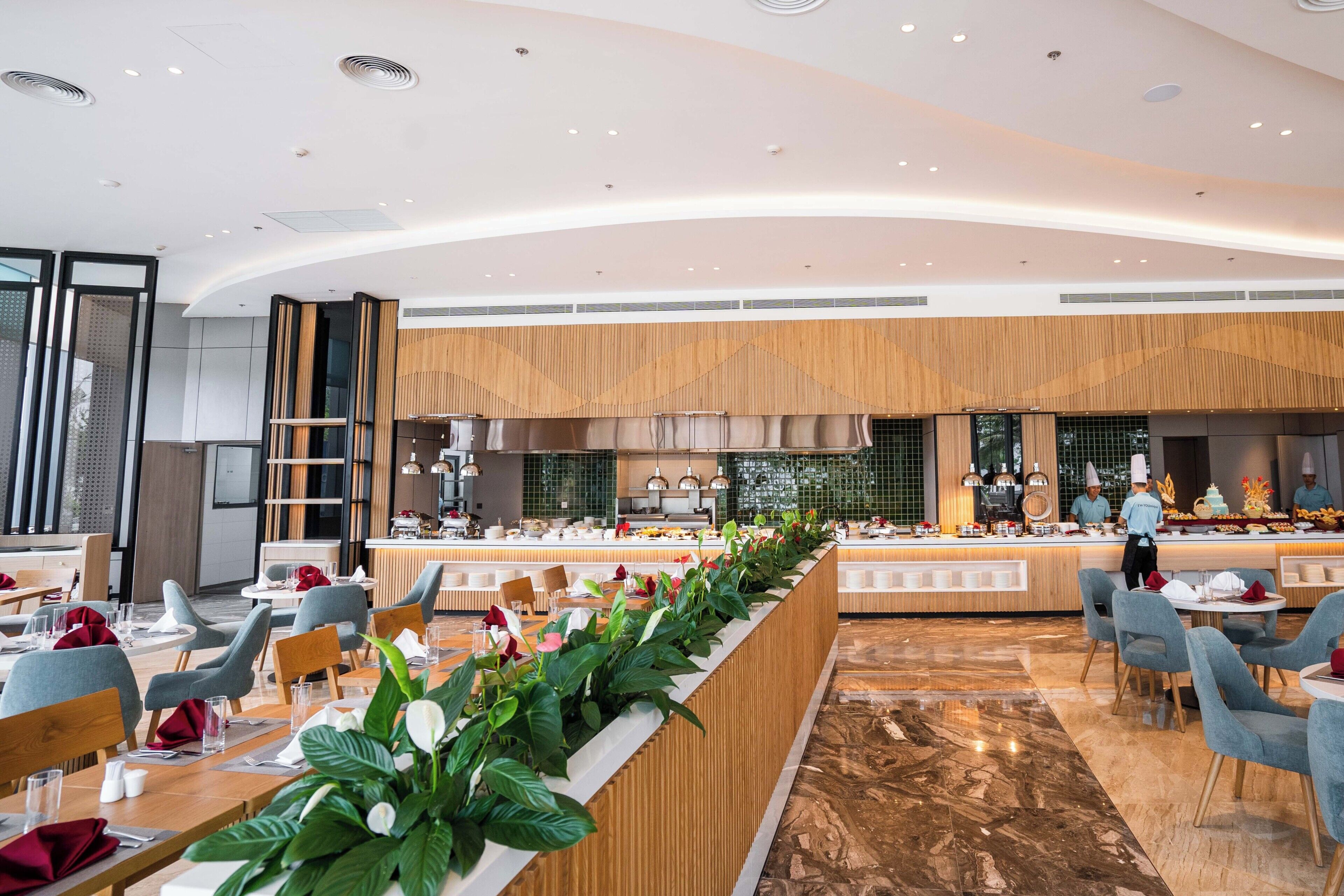 Een modern restaurant met een lange toonbank, een zithoek en een keuken op de achtergrond.