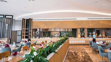 Een modern restaurant met een lange toonbank, een zithoek en een keuken op de achtergrond.