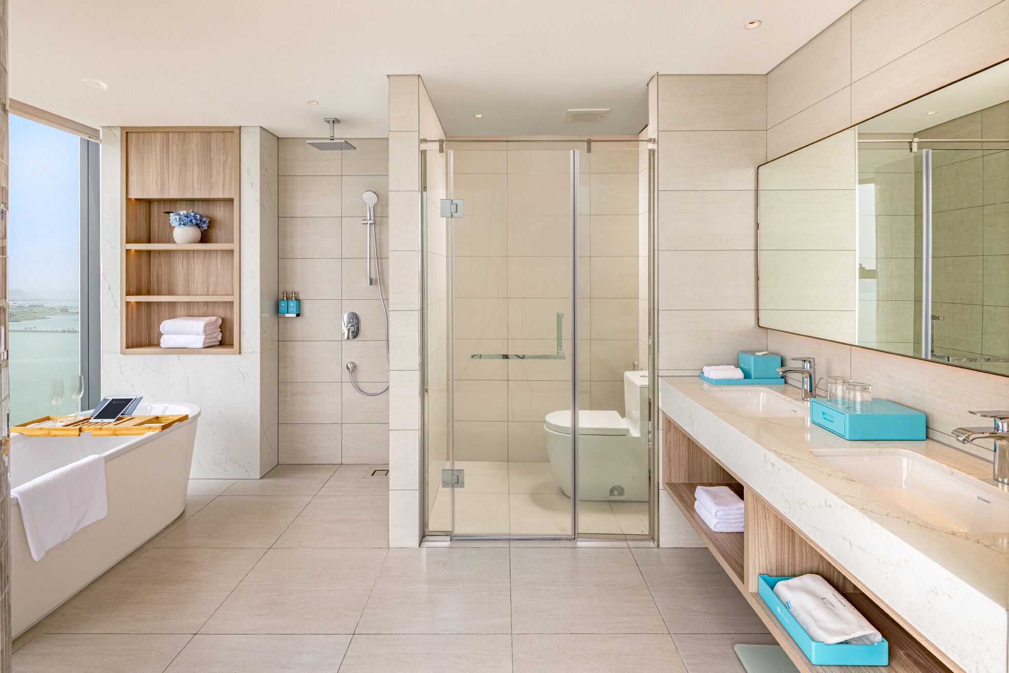 Une salle de bain moderne dotée d’une douche à parois de verre, d’une baignoire, de toilettes et d’un meuble-lavabo avec un grand miroir.